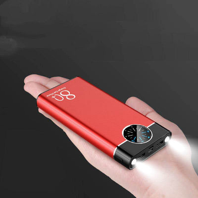 Red fast charging mobile power supply with brand logo and built-in flashlight held in hand against dark background
