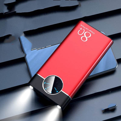 Red fast charging mobile power supply power bank with digital display and dual flashlight beams on black surface
