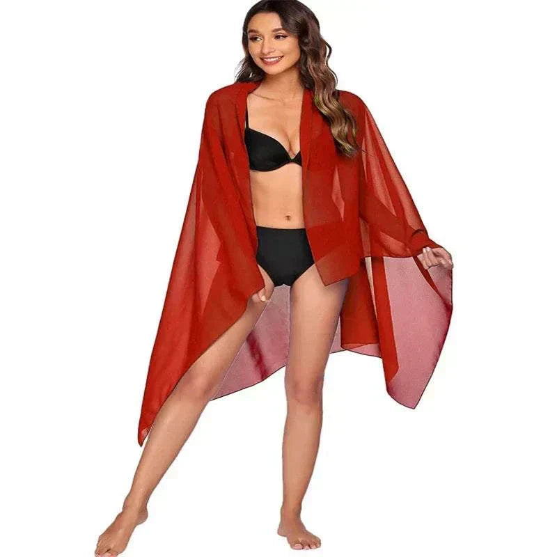 Woman wearing a red chiffon beach skirt for women over black bikini beachwear
